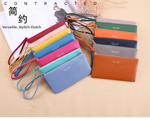 Flat lay of multiple minimalist leather wallets with wristlets in 12 varied colors