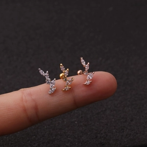 Close-up of three leaf-shaped stud earrings in silver, gold, and rose gold with zircons