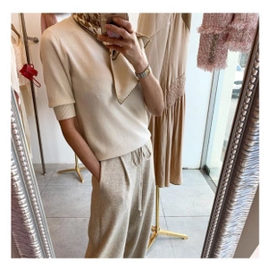 Detalle de conjunto de punto blanco crema con top de manga corta y pantalón de pierna ancha