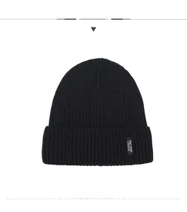 Close-up of black ribbed knit beanie featuring an embroidered DZMY SPORT textile label