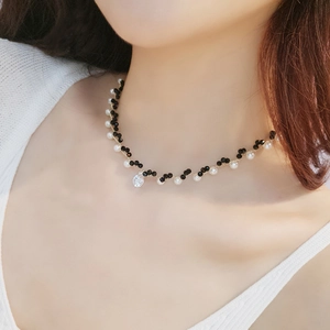 Fashionable choker necklace with gold chain, black and white beads, and crystal pendant