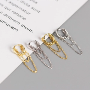 Detail view of gold and silver S925 sterling silver hoop earrings with double chain tassels