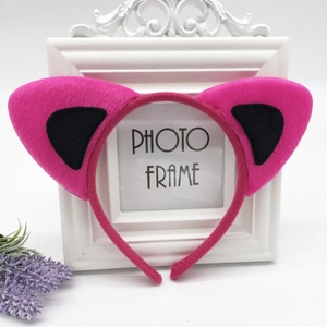 Detail of soft rose red and black plush cat ear headband on a white decorative frame