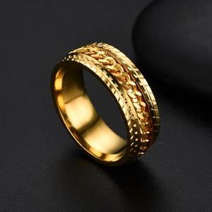 Detail of a gold stainless steel spinner ring with tire tread texture and rotating chain