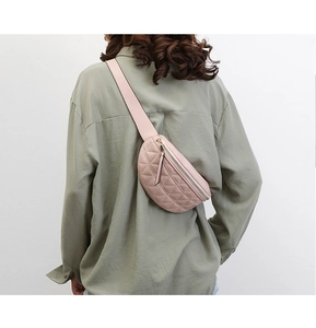 Roze gewatteerde heuptas met brede schouderriem gedragen als crossbodytas op de rug