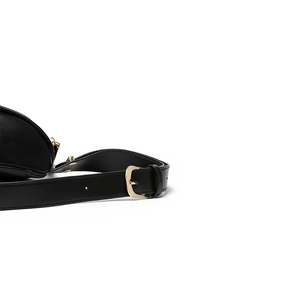 Detail van zwarte lederen riem met gouden metalen gesp en hardware voor de heuptas