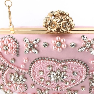 Detailed shot of pink satin evening clutch with intricate pearl and rhinestone embroidery