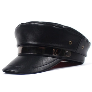 Close-up of black faux leather flat cap featuring a gold metal chain and M initial charm