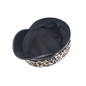 Detail of leopard print baker boy hat with black fabric lining and metallic buttons