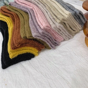 Close-up of multicolored ribbed knit wool blend socks stacked neatly on linen fabric