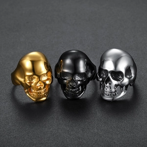 Detailed close-up of skull rings in gold, black, and silver polished stainless steel