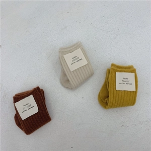 Flat lay of thick wool blend socks in beige, caramel, and ginger yellow with stripe detail