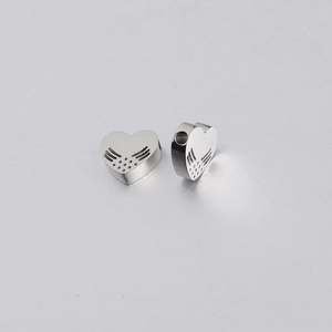 Macro view of heart-shaped stainless steel beads with wing texture and side hole