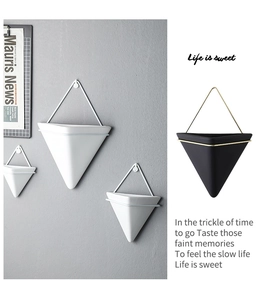 Detail of geometric ceramic wall planter with metal frame for modern Nordic home decor