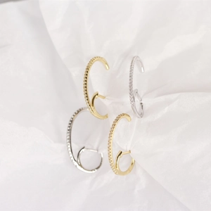 Detailed view of gold and silver S925 sterling silver hoop earrings with pavé crystals