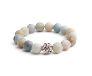Macro detail of natural stone beaded bracelet with rose gold pavé crystal charm