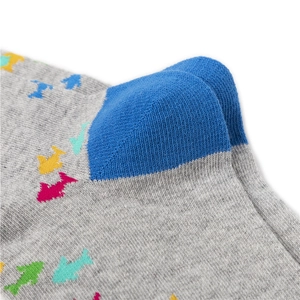 Vue macro de chaussettes en coton peigné gris avec talon bleu et motif poisson pixelisé