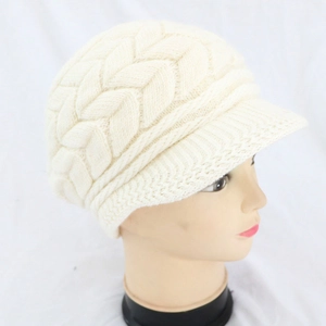 Dettaglio della trama del cappello di maglia beige con visiera su un manichino