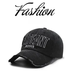 Detailed view of white 3D embroidery on black washed denim baseball cap with frayed edges