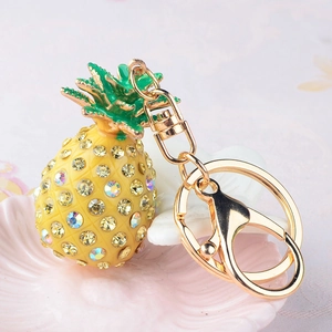 Glittering yellow pineapple keychain with green leaves and rhinestones on a golden ring