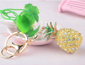 Close-up of a sparkling pineapple keychain with yellow rhinestones and gold-tone clasp