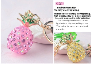 Detailed view of pink and yellow rhinestone pineapple keychains with gold plating