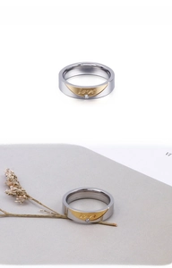 Detailed close-up of titanium steel couple ring with gold inlay and small diamond accent