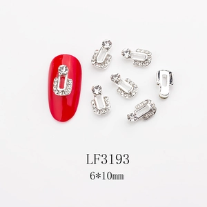 U-shaped nail charms with sparkling rhinestones and red manicure demonstration