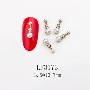 Macro detail of retro gold alloy nail jewelry with pearls in a vertical drop design