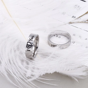 Polished stainless steel couple rings with I Love You engraving on soft white feathers