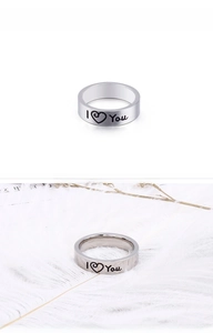 Macro detail of silver stainless steel band ring with I LOVE YOU engraving and heart icon