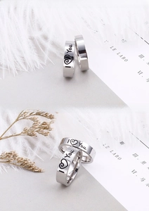 Macro shot of stainless steel rings with I LOVE YOU engraving on white feathers