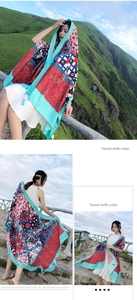Detailed shot of ethnic geometric print scarf with turquoise borders and tassels