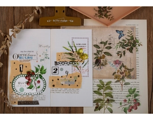 Flat lay of vintage plant PET stickers featuring berries and leaves on a wooden desk