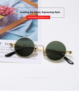 Detailed view of vintage gold metal round sunglasses with dark green lenses on white background