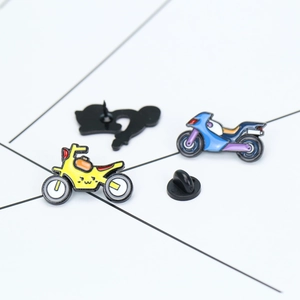 Detail of colorful motorcycle enamel pins featuring yellow and purple cartoon bikes