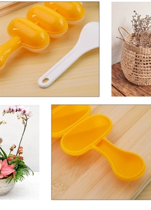 Detail of yellow ball-shaped rice ball mold with a white scoop on a wooden table