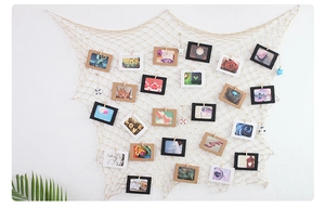 Detail of Mediterranean nautical fish net photo wall with colorful clips and LOVE cards