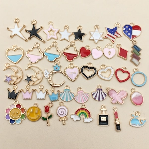 Assorted colorful enamel metal charms in shapes of stars, hearts, and perfume bottles