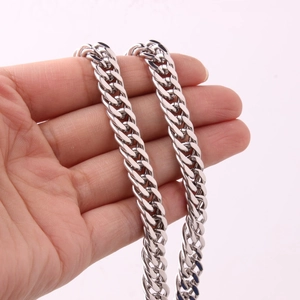 Close-up of polished silver double buckle Cuban chain necklace showing texture and shine