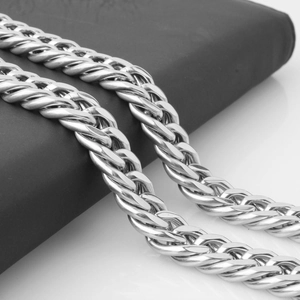 Macro shot of silver heavy curb chain necklace with polished woven texture details