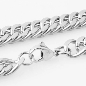 Macro shot of a silver curb chain necklace with a secure lobster clasp closure