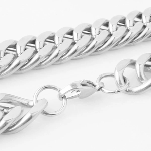 Macro shot of silver curb chain link details and sturdy lobster clasp for men's necklace
