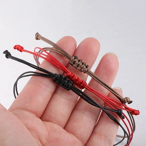 Detail of adjustable 0.8mm waxed cord bracelets in black, red, and brown colors