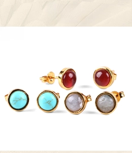 Close-up of circular stone earrings in turquoise, red agate, and grey labradorite