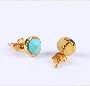 Detailed close-up of turquoise stud earrings with gold plating and butterfly backings