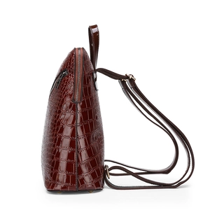 Brown crocodile pattern leather mini backpack with adjustable straps on white background
