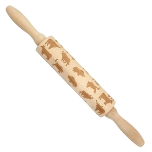 Close-up of wooden rolling pin with engraved horse, cow, and pig patterns for baking