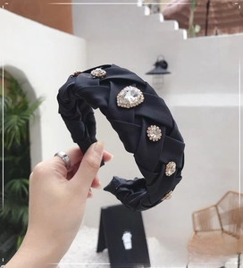 Detail of hand-woven black satin headband featuring large crystal rhinestones