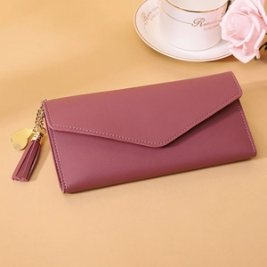 Deep purple long envelope wallet with gold heart tassel on a beige lifestyle background